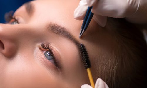 Beautician plucking eyebrows. Eyebrow care in a beauty salon